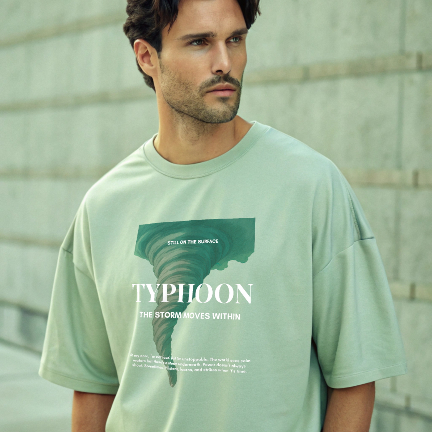 Man wearing a light green t-shirt with 'Typhoon' graphic design developed by boone and beetle