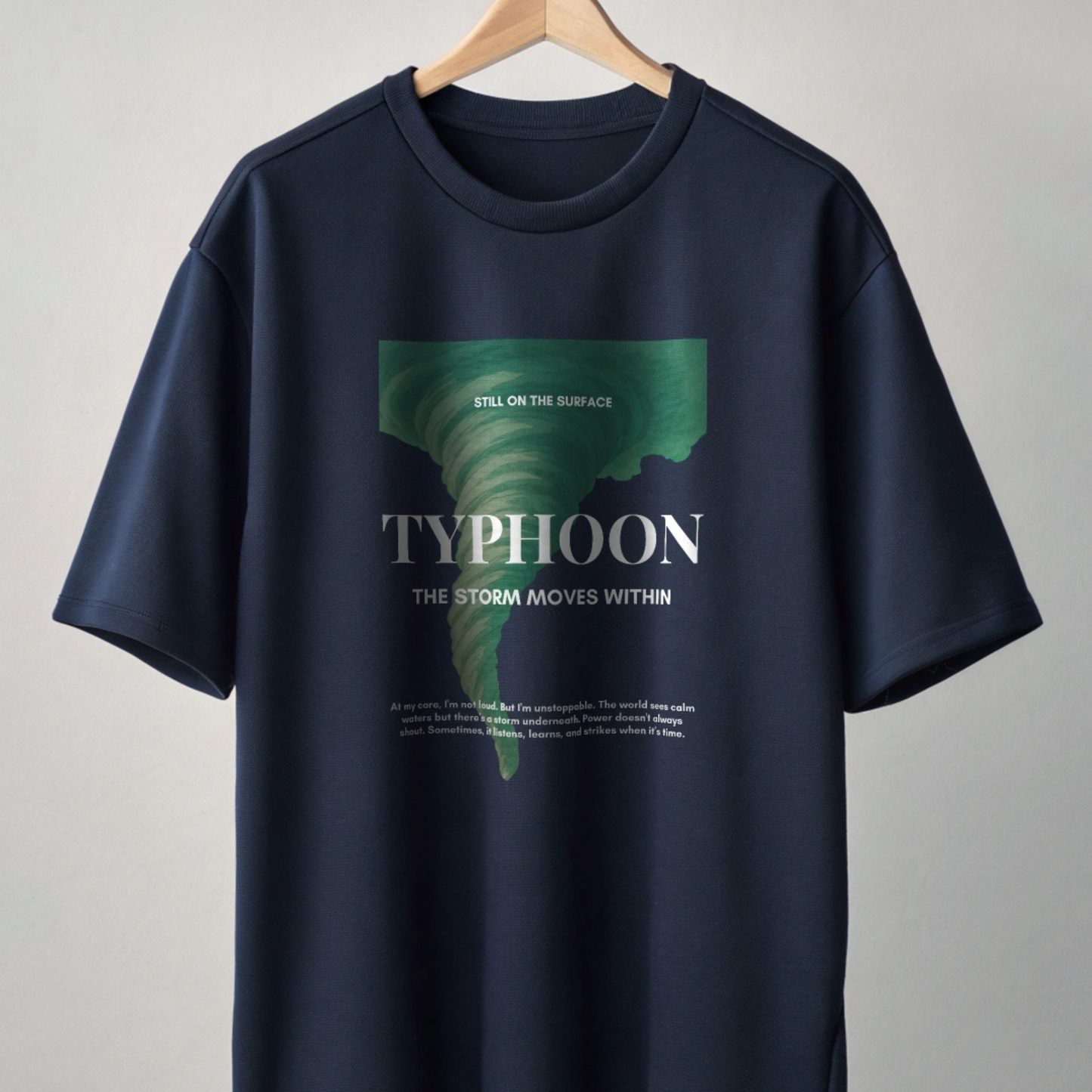 Navy blue t-shirt with green and white graphic design on a gray background by boone and beetle